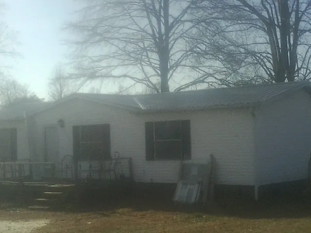 New metal roof on a white painted brick home on a foggy morning in Sopchoppy